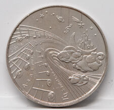 Nahaufnahme der Motivseite: Ein traumhaftes Ensemble aus Notenlinien, Sternen, Planeten und litauischen Textfragmenten. Zu sehen sind schlafende Hasen und ein Schloss auf dem Mond. Die Prägung besticht durch ihre feinen Linien und moderne Ästhetik.