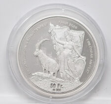 Prachtvolle Vorderseite des Silberschützentalers 2026: Ein majestätischer Bündner Steinbock vor der Skyline von Chur und den Schweizer Alpen, kombiniert mit der klassischen Helvetia-Symbolik, die in der kühlen Eleganz des Silbers höchste Detailtiefe ausstrahlt.